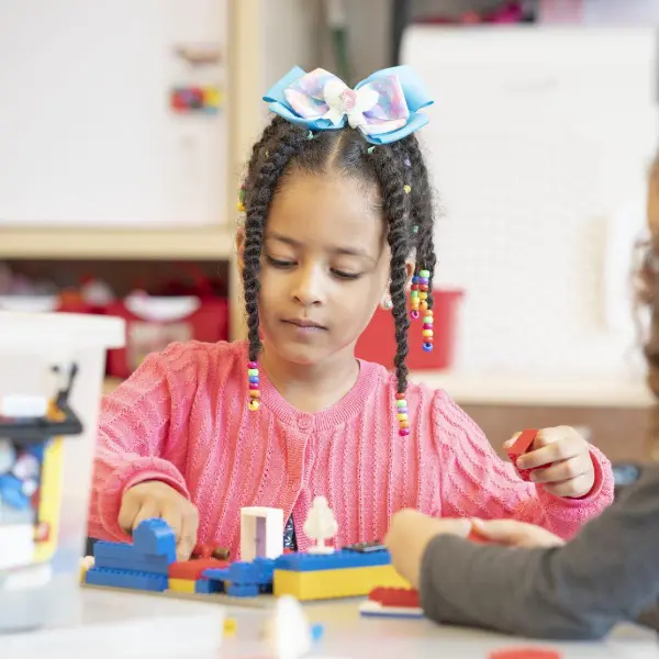 Female youth working with legos.