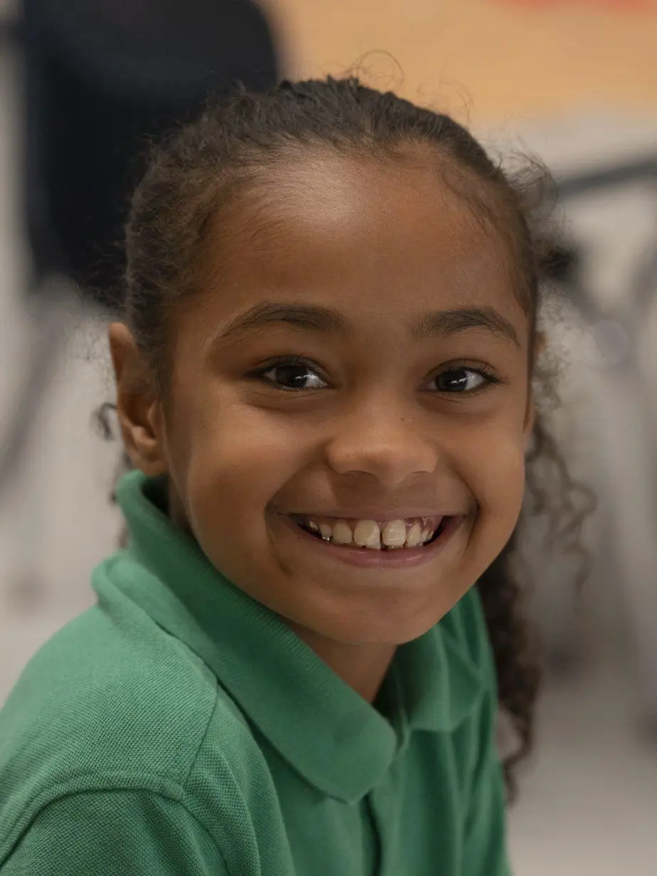 Smiling girl student in green polo shirt